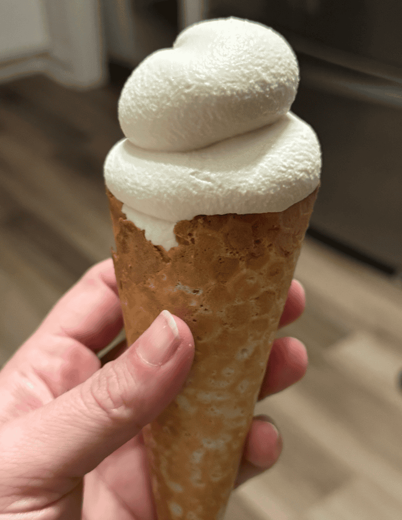 Delicious vanilla ice cream cone with two scoops in a waffle cone.