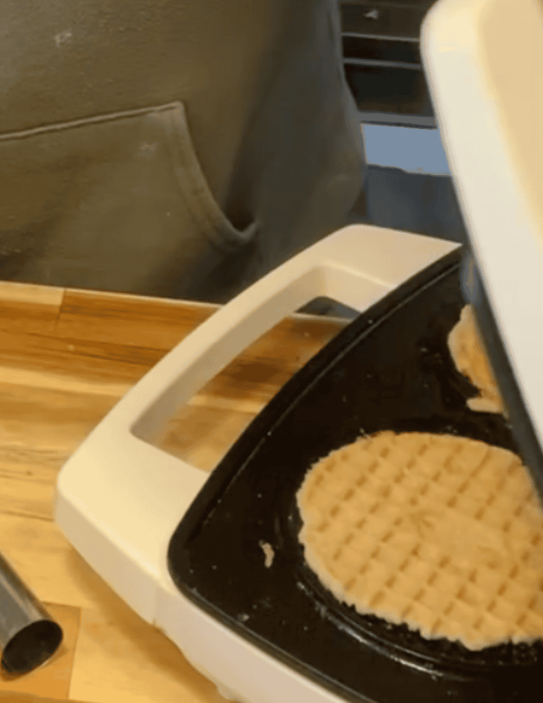 Cooking waffle cookies on a waffle iron for gluten-free dessert.